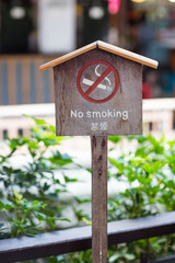 No smoking sign against a wood wall. The white non-smoking sign on the wooden floor is a sign that...
