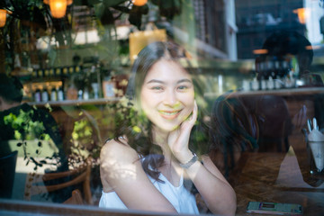 Fototapeta na wymiar Smiling asian busines women siting in art cafe