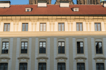 Fototapeta na wymiar Wall background of old city buildings in Prague, Czech Republic, walls of retro buildings and red tile roofs