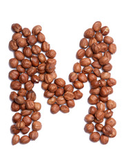 Letter M of the English alphabet from from hazelnut on a white isolated background. Food pattern made from nuts. Bright alphabet for shops.