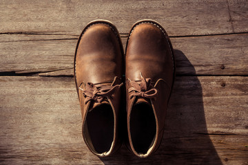 Brown stylish boots on wood background,  retro color