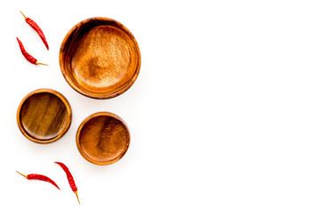 Asian cuisine concept. Wooden bowls and chili pepper on white background top view copy space