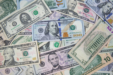 Money American dollar bills .Pile of various currencies isolated on white background. Closeup of assorted American banknotes.US currency scattered on the table. America currency.