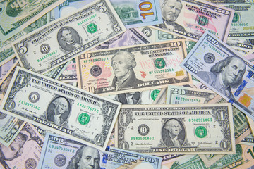 Money American dollar bills .Pile of various currencies isolated on white background. Closeup of assorted American banknotes.US currency scattered on the table. America currency.