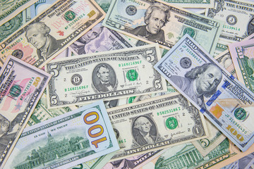 Money American dollar bills .Pile of various currencies isolated on white background. Closeup of assorted American banknotes.US currency scattered on the table. America currency.