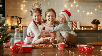 happy family mother and children bake christmas cookies.