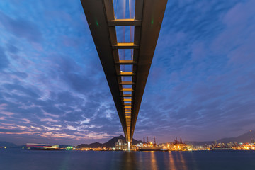 Cutterstone bridge and cargo port in Hong Kong city at dusk