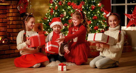 Fototapeta na wymiar Merry Christmas! happy children with gifts at evening home