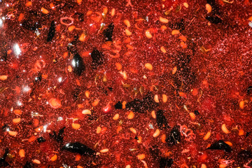 Cooking raspberry jam in a large pan.