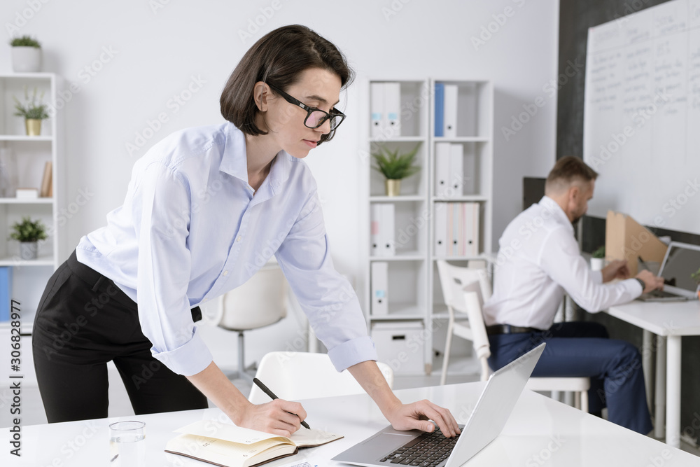 Aufkleber confident businesswoman bending over desk in front of laptop while networking