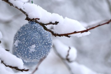 Christmas ball with beads decor on snowy branches in the winter garden background.Christmas and New Year winter festive background.IPhone Wallpaper. Winter festive decor street