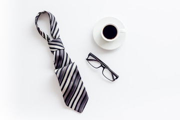 Father's day concept. Card with men's tie, glasses, coffee on white background top-down copy space