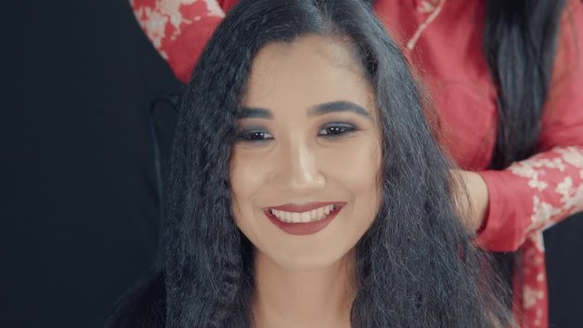 Portrait of young beautiful woman with make up making a hairstyle in cosmetics studio 