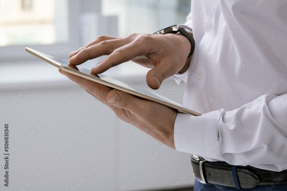 Poster Hands of elegant businessman with tablet scrolling through online data