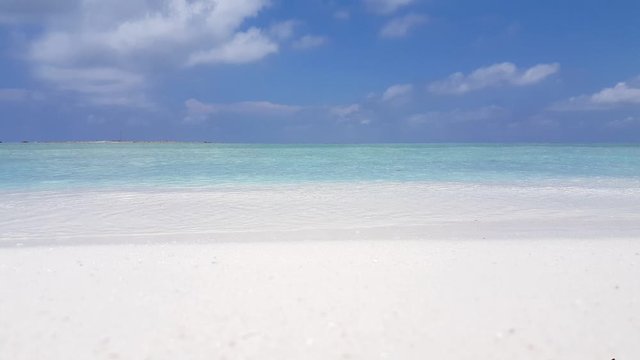 The Cook Islands - The Calm Waves Of The Shallow Ocean Gently Stikes The Shore And Its Fine White Sand Beach Under A Clear Blue Summer Sky - Close Up Shot