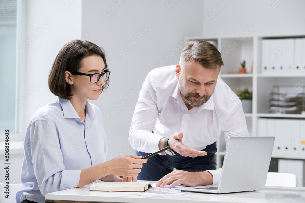 Poster Two professional economists pointing at laptop display while discussing data