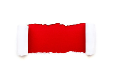 A hole in white paper with torn edges isolated on a white background with a bright red color paper...