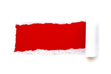 A hole in white paper with torn edges isolated on a white background with a bright red color paper background inside. Good paper texture.
