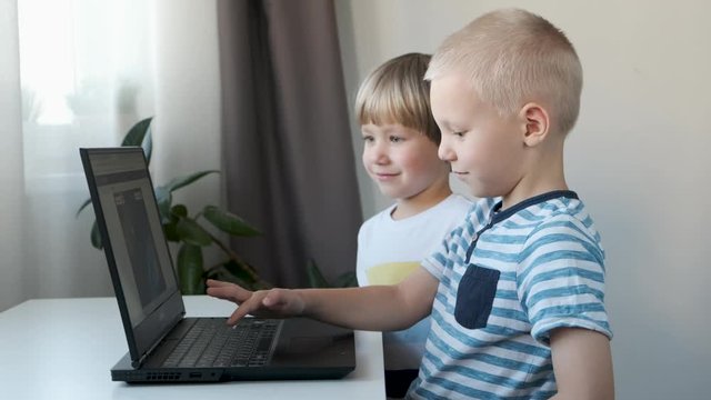 Boys, children working on a computer, programming, learning or playing
