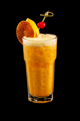 Closeup glass of fresh orange juice shake decorated with winter cherry isolated at black background.