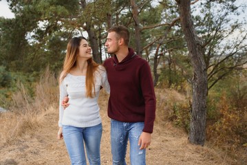 Fototapeta premium Beautiful young couple walking in autumn park.