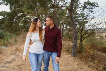 Beautiful young couple walking in autumn park.