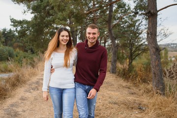 Beautiful young couple walking in autumn park.