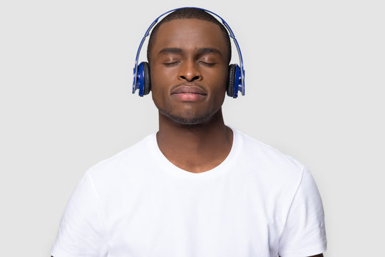 Satisfied African American Man In Headphones Enjoying Favorite Music