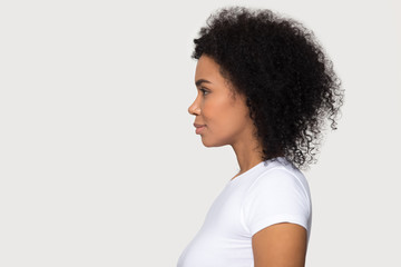 Young attractive African American woman standing in profile isolated