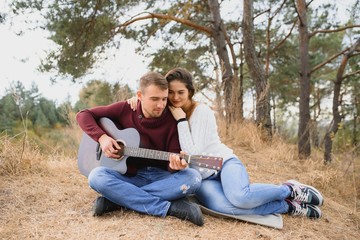 Beautiful young couple walking in autumn park.