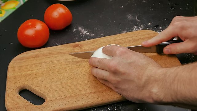 cooking pizza Margarita . cut the cheese mazzarella on the background of tomatoes . 4k