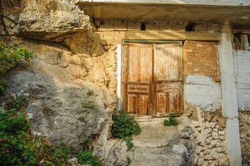 The yellow old door in the stone wall of the monastery