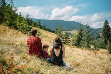 Family stay on the top of mountain, looking on the beautiful view.