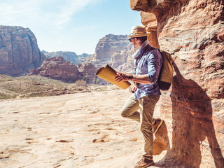 Handsome man, exploring the sights of the ancient, fabulous city of Petra in Jordan. Colorful...