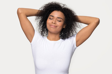 Calm African American woman relaxing with hands behind head