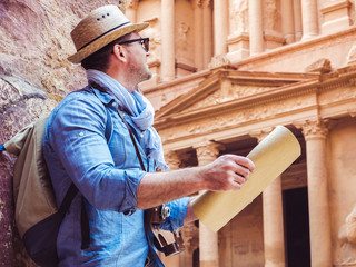 Handsome man, exploring the sights of the ancient, fabulous city of Petra in Jordan. Colorful photos. Concept of leisure, vacation and travel