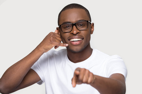 Smiling African American man in glasses showing call me gesture