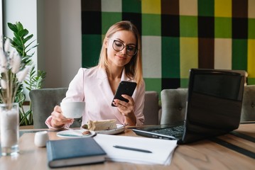 beautiful business lady drinking coffee and uses different gadgets