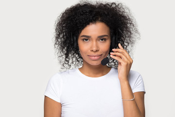 Head shot African American woman in headset, call center operator