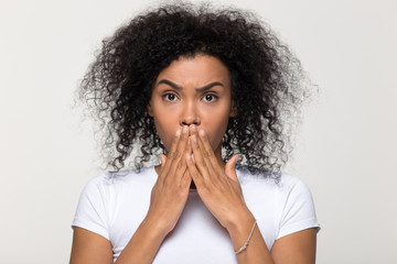 Shocked African American woman covering mouth with hands