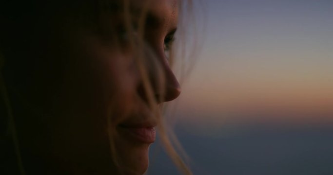 Slow motion close up of young woman is enjoying a start of a summer vacation on a beach with a sea on a sunset.