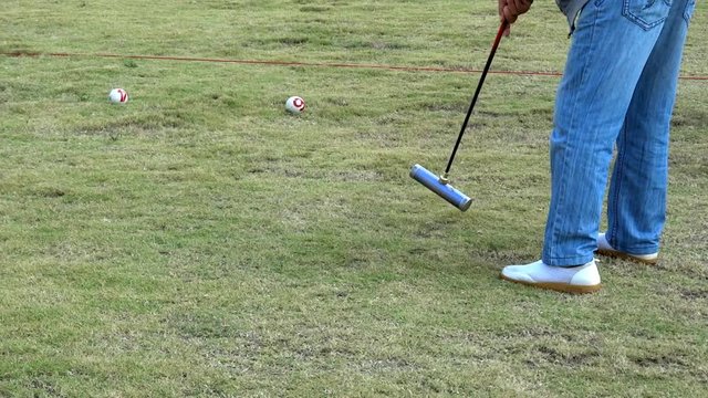 A male gate ball player hit gate ball in slow motion. Gateball is a fast paced, non contact, highly strategic team game.