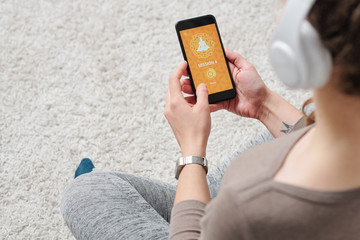 Hands of young active female going to watch yoga video in smartphone
