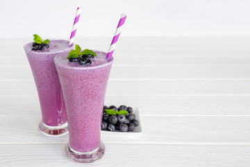 Blueberry Juice smoothies drink in a glass drink purple colorful fruit juice milkshake blend beverage healthy high protein the taste yummy in glass on white wood background.