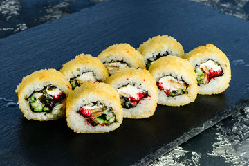 baked sushi on a black stone