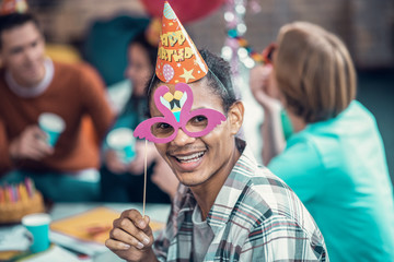 Birthday man holding glass while having birthday party with friends
