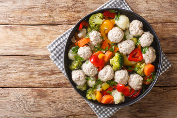 Serving soup with meatballs and vegetables close-up in a plate. Horizontal top view