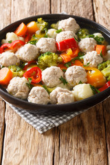 Healthy soup with chicken meatballs and vegetables close-up in a plate on the table. vertical