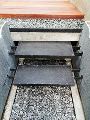 Steel stairs in with gravel and wood surface and natural wall material