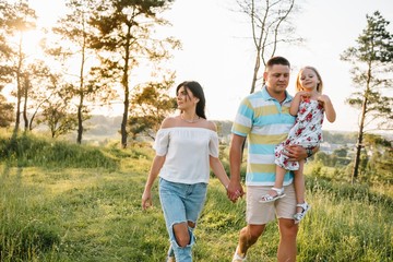 Fototapeta premium happy family concept - father, mother and child daughter having fun and playing in nature.
